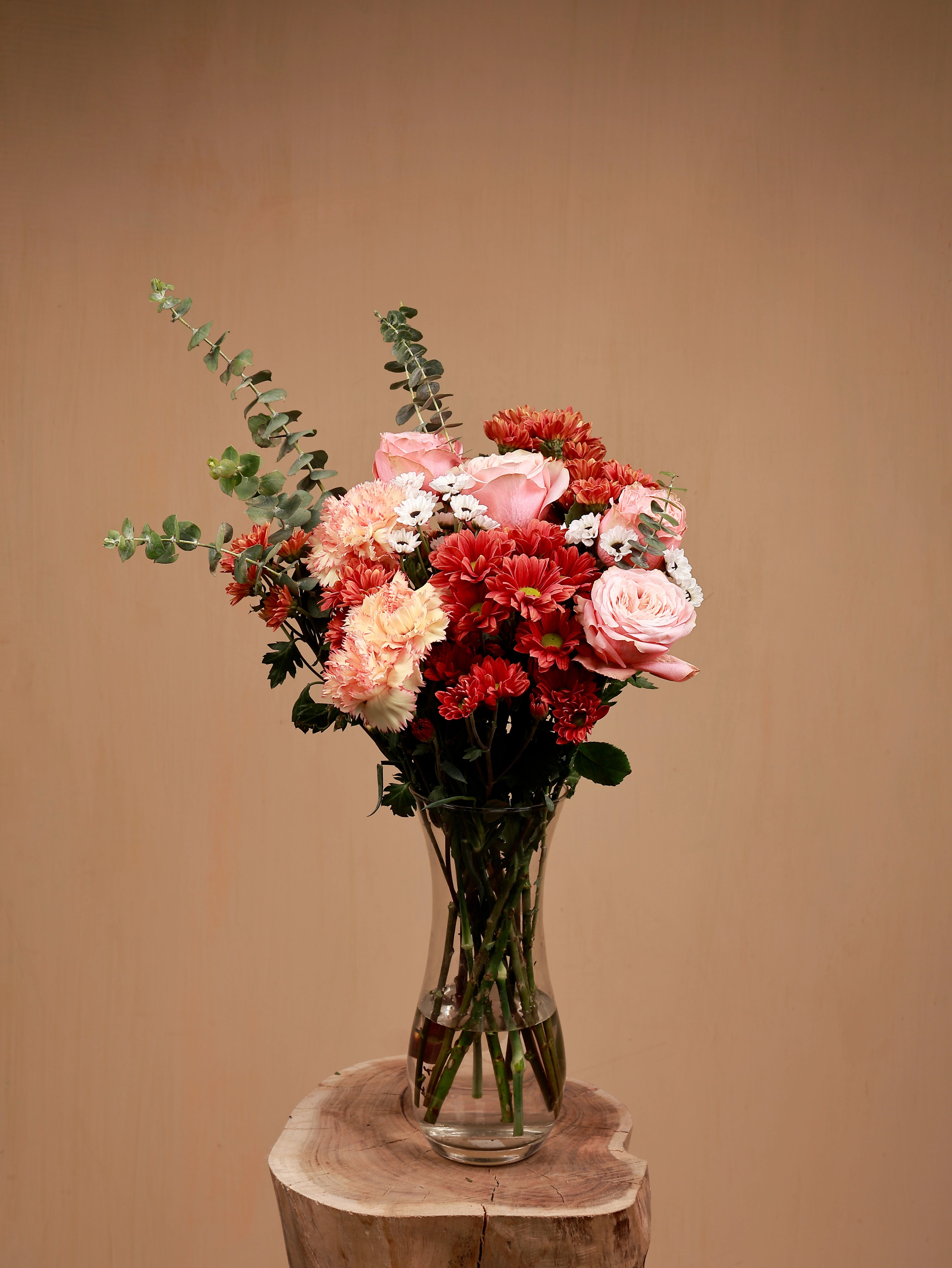 carnation and santini bouquet in a glass-vase with pink roses